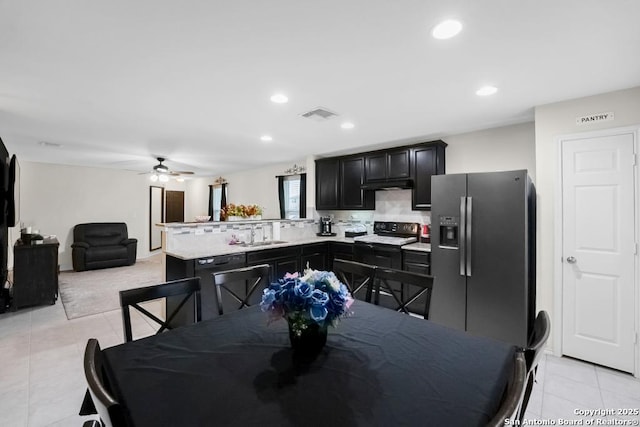130 Texas Lantana, New Braunfels, TX 78130 - kitchen with light countertops, black appliances, a peninsula, light tile patterned floors, and dark cabinetry