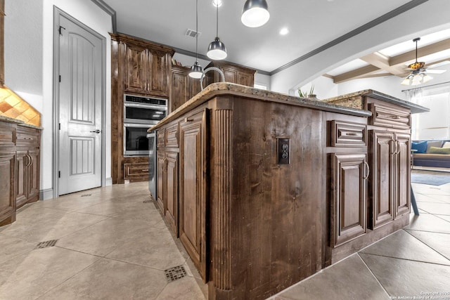 27306 Dana Crk, Boerne, TX 78015 - kitchen with double oven, crown molding, a ceiling fan, beam ceiling, and pendant lighting