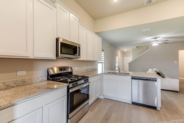 13609 Mineral Wl, San Antonio, TX 78253 - kitchen featuring stainless steel appliances, a peninsula, light wood-style floors, white cabinets, and recessed lighting