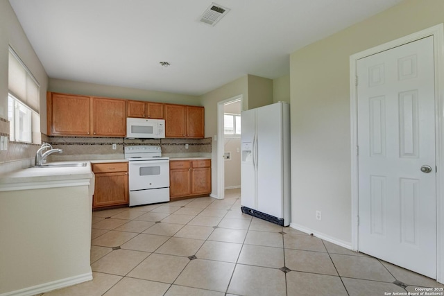 11906 Creek Peak, San Antonio, TX 78253 - kitchen featuring white appliances, light countertops, backsplash, brown cabinets, and light tile patterned floors