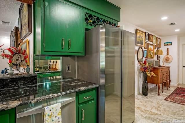 505 Winfield Blvd, Windcrest, TX 78239 - kitchen with green cabinetry, recessed lighting, a textured ceiling, dark stone counters, and freestanding refrigerator