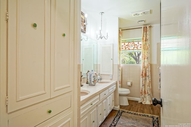 505 Winfield Blvd, Windcrest, TX 78239 - full bath featuring wood finished floors, double vanity, tile walls, and wainscoting