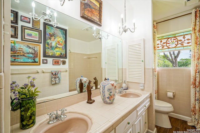 505 Winfield Blvd, Windcrest, TX 78239 - full bath with tile walls, double vanity, a chandelier, wood finished floors, and wainscoting