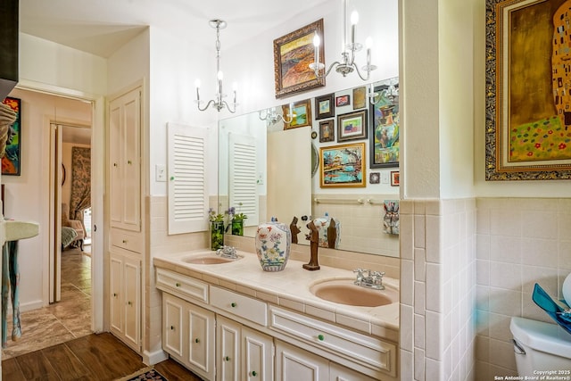 505 Winfield Blvd, Windcrest, TX 78239 - full bathroom featuring double vanity, tile walls, a chandelier, and wood finished floors