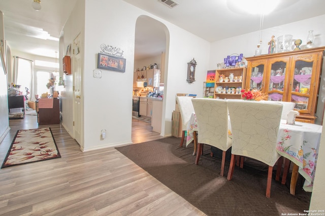 9075-1 W Foxgrove Way, San Antonio, TX 78251 - dining area with arched walkways and light wood-style flooring