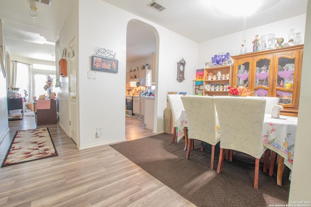 9075-1 W Foxgrove Way, San Antonio, TX 78251 - dining space with arched walkways and wood finished floors