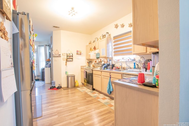 9075-1 W Foxgrove Way, San Antonio, TX 78251 - kitchen with stainless steel appliances, light wood-style floors, light brown cabinets, under cabinet range hood, and light countertops