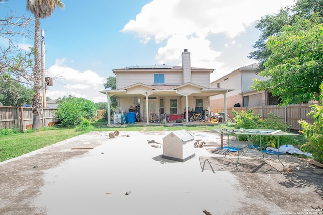 9075-1 W Foxgrove Way, San Antonio, TX 78251 - back of house featuring a chimney, solar panels, a fenced backyard, and a patio area