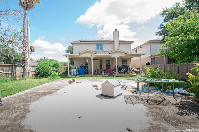 9075-1 W Foxgrove Way, San Antonio, TX 78251 - rear view of house with roof mounted solar panels, a chimney, a patio area, and a fenced backyard