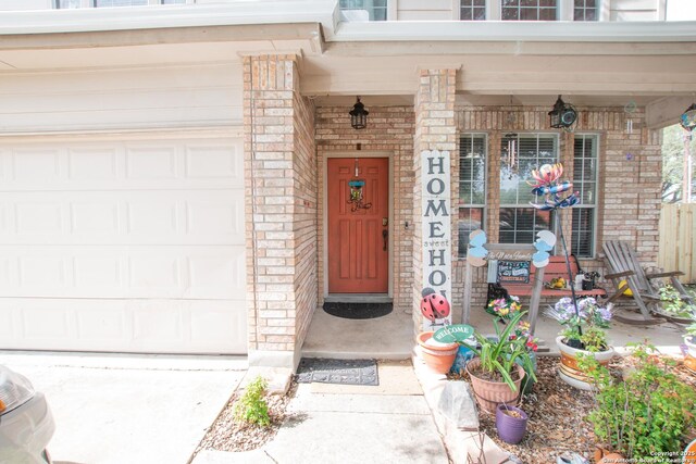 9075-1 W Foxgrove Way, San Antonio, TX 78251 - property entrance featuring a porch, brick siding, and an attached garage