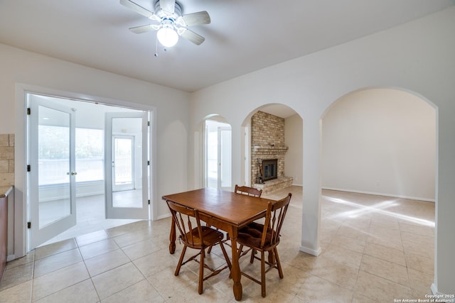 2814 Rim Rock, San Antonio, TX 78251 - dining room featuring light tile patterned floors, ceiling fan, arched walkways, and a fireplace