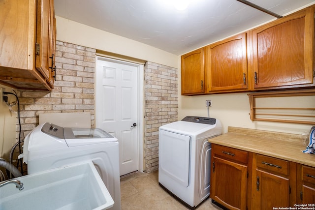 2814 Rim Rock, San Antonio, TX 78251 - laundry area with cabinet space, washer and dryer, light tile patterned floors, and brick wall