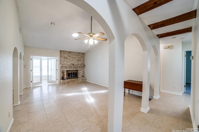 2814 Rim Rock, San Antonio, TX 78251 - unfurnished living room featuring ceiling fan, light tile patterned flooring, a brick fireplace, and arched walkways