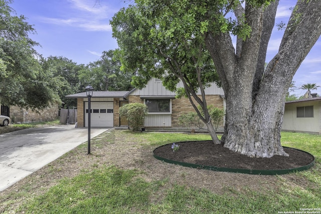11115 Rendezvous, San Antonio, TX 78216 - view of front of property with driveway, brick siding, an attached garage, and board and batten siding