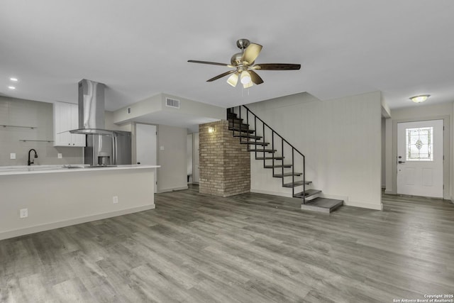 11115 Rendezvous, San Antonio, TX 78216 - unfurnished living room with wood finished floors, a ceiling fan, and stairway
