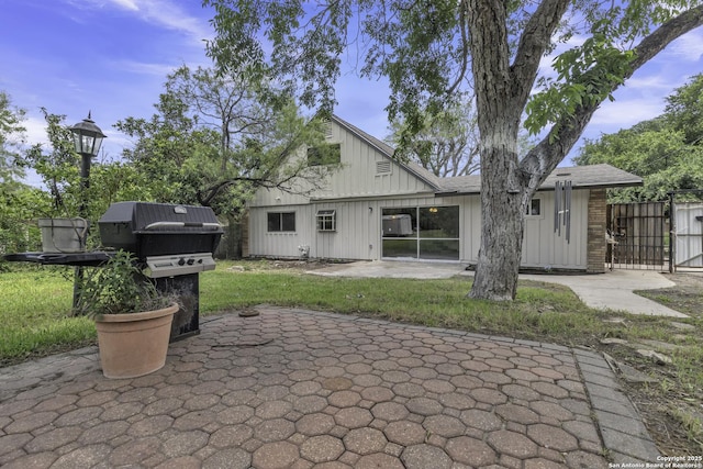 11115 Rendezvous, San Antonio, TX 78216 - rear view of house with a patio area, board and batten siding, and a gate