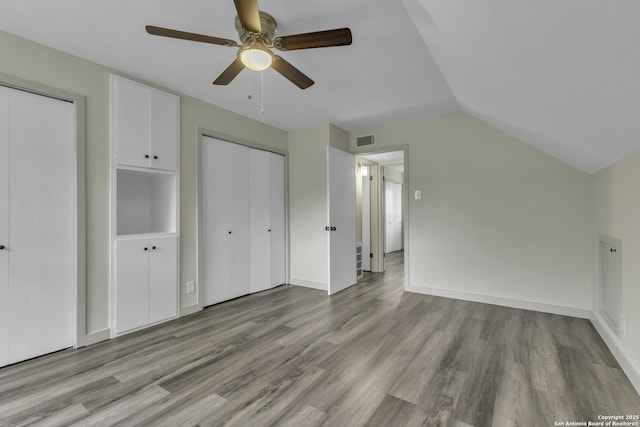 11115 Rendezvous, San Antonio, TX 78216 - unfurnished bedroom with wood finished floors, lofted ceiling, a ceiling fan, and multiple closets