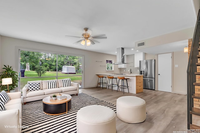 11115 Rendezvous, San Antonio, TX 78216 - living room with ceiling fan, light wood-style floors, recessed lighting, and stairway