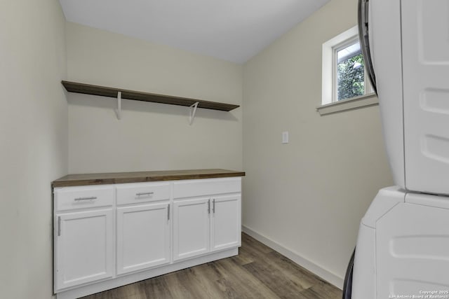 11115 Rendezvous, San Antonio, TX 78216 - laundry room featuring stacked washing machine and dryer, wood finished floors, and cabinet space