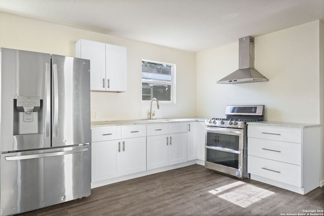 211 Sylvia, San Antonio, TX 78237 - kitchen with appliances with stainless steel finishes, wall chimney range hood, white cabinets, dark wood-style flooring, and light countertops