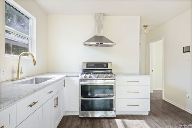 211 Sylvia, San Antonio, TX 78237 - kitchen featuring wall chimney range hood, double oven range, dark wood-type flooring, white cabinets, and light stone countertops