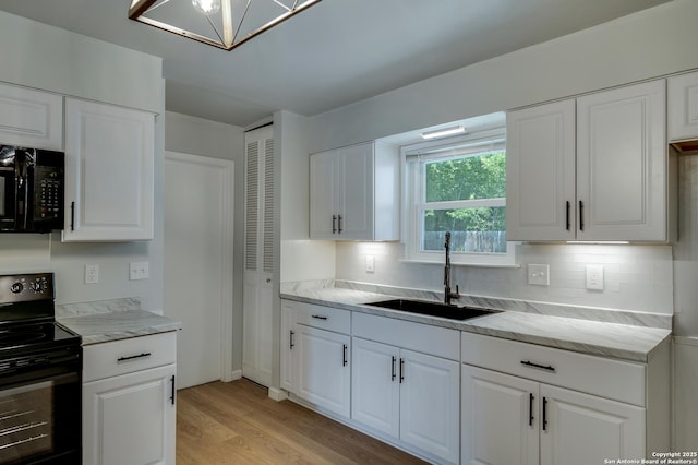 8302 Hastings, San Antonio, TX 78239 - kitchen featuring black appliances, backsplash, light wood-type flooring, and white cabinetry