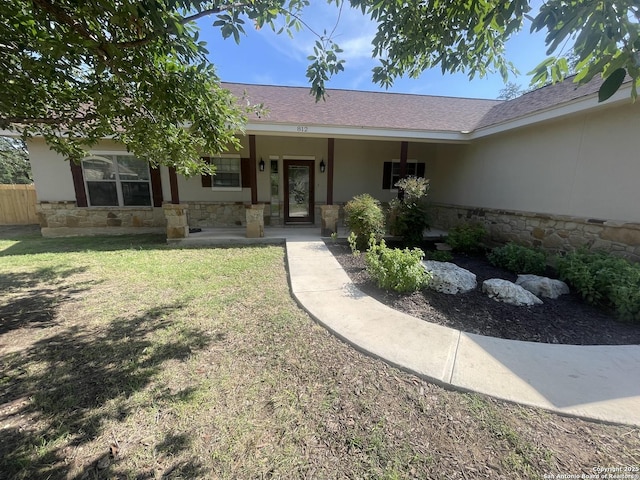 812 33rd St, Hondo, TX 78861 - doorway to property with stone siding, a porch, a shingled roof, and stucco siding