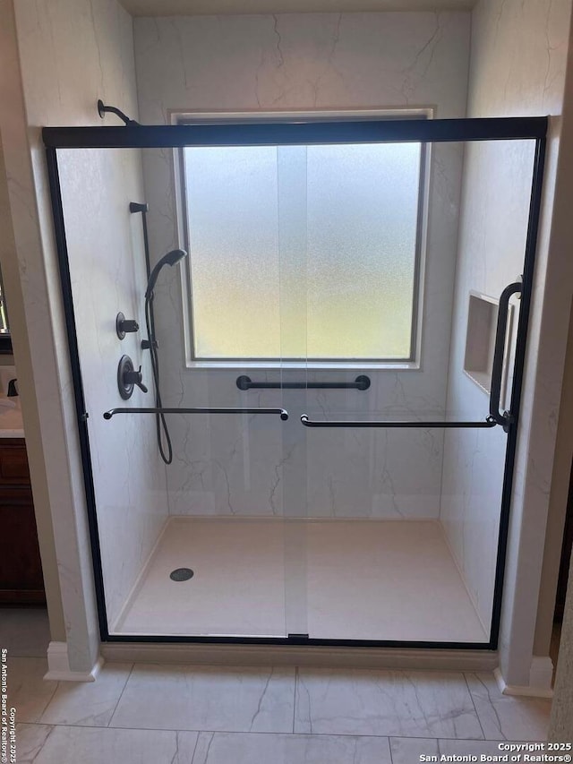 812 33rd St, Hondo, TX 78861 - full bath featuring a marble finish shower, marble finish flooring, and vanity