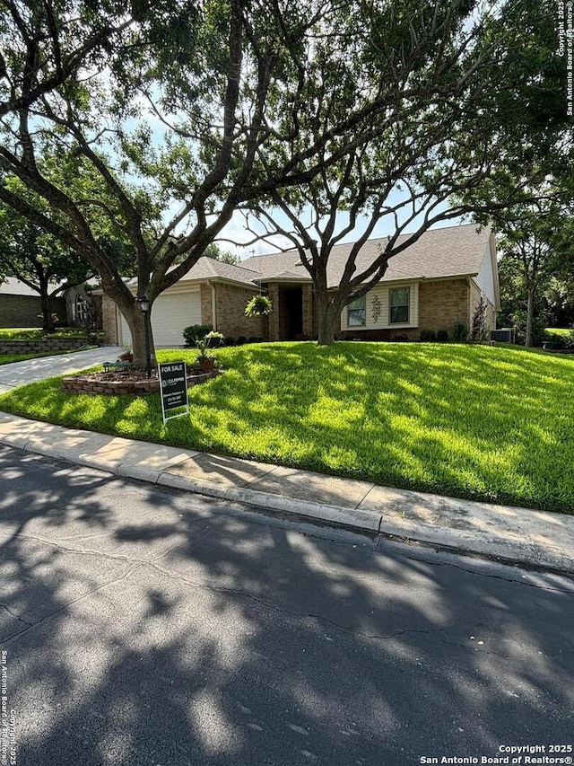 3716 Scenic Dr, Schertz, TX 78108 - view of front of house with concrete driveway, a front lawn, an attached garage, and brick siding