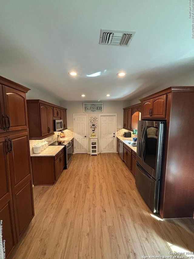 3716 Scenic Dr, Schertz, TX 78108 - kitchen with stainless steel appliances, beverage cooler, light wood-style floors, light countertops, and recessed lighting