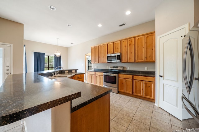 312 Bunker Hl, Pleasanton, TX 78064 - kitchen featuring stainless steel appliances, dark countertops, light tile patterned floors, brown cabinets, and recessed lighting