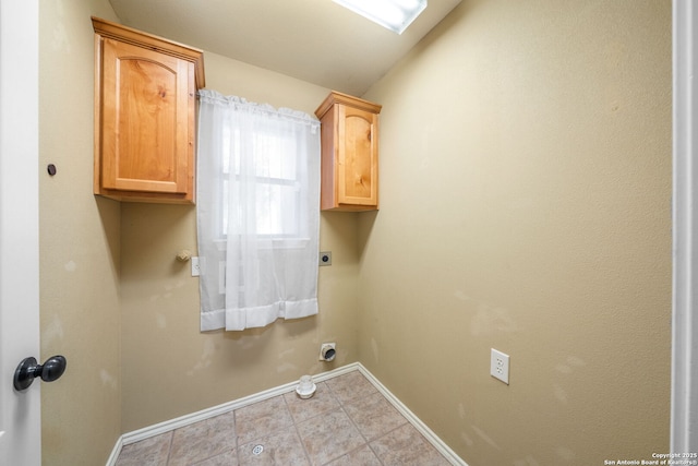 312 Bunker Hl, Pleasanton, TX 78064 - laundry area featuring electric dryer hookup, cabinet space, and light tile patterned floors