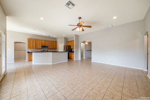 312 Bunker Hl, Pleasanton, TX 78064 - kitchen featuring appliances with stainless steel finishes, arched walkways, open floor plan, dark countertops, and ceiling fan