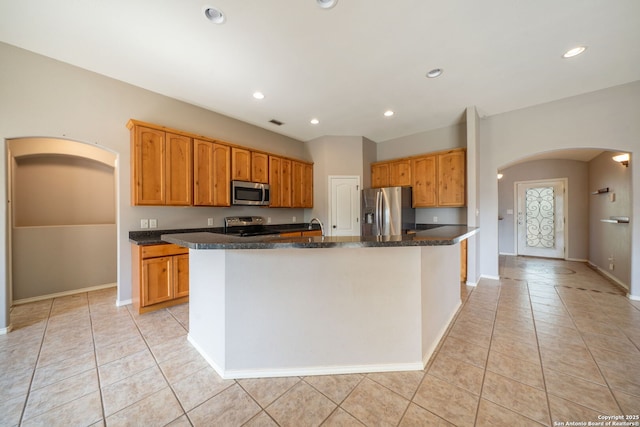 312 Bunker Hl, Pleasanton, TX 78064 - kitchen featuring stainless steel appliances, arched walkways, light tile patterned floors, an island with sink, and recessed lighting