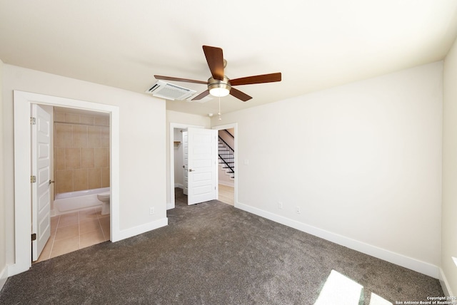 419 Ira Ave Unit 1102, San Antonio, TX 78209 - unfurnished bedroom with carpet flooring, ensuite bath, tile patterned flooring, a spacious closet, and a ceiling fan