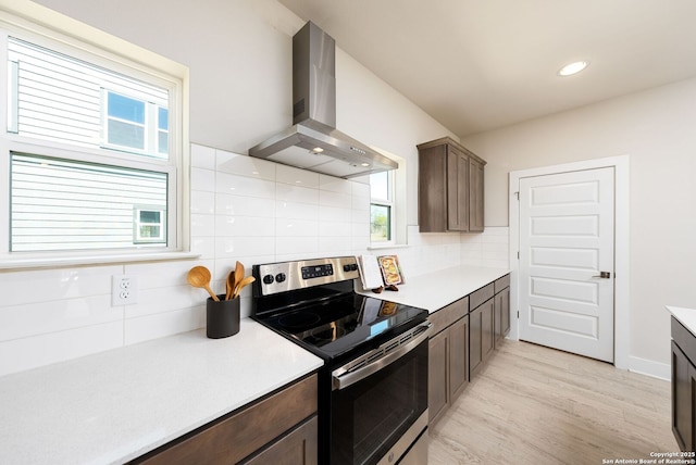 419 Ira Ave Unit 1102, San Antonio, TX 78209 - kitchen featuring stainless steel electric stove, exhaust hood, backsplash, light countertops, and light wood-type flooring