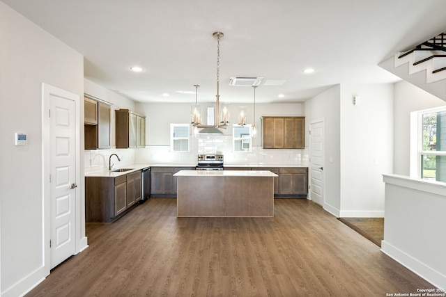 419 Ira Ave Unit 2101, San Antonio, TX 78209 - kitchen featuring stainless steel appliances, a center island, tasteful backsplash, dark wood-style flooring, and light countertops