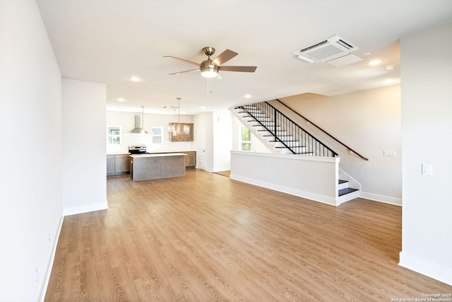 419 Ira Ave Unit 2101, San Antonio, TX 78209 - unfurnished living room featuring ceiling fan, stairway, light wood-style floors, recessed lighting, and healthy amount of natural light