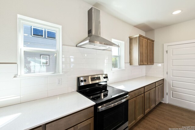 419 Ira Ave Unit 2101, San Antonio, TX 78209 - kitchen featuring stainless steel range with electric stovetop, wall chimney range hood, decorative backsplash, light countertops, and recessed lighting