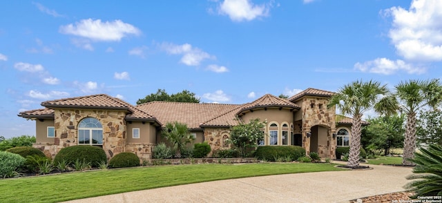 1437 Decanter, New Braunfels, TX 78132 - mediterranean / spanish home featuring stone siding, stucco siding, a tiled roof, and a front lawn