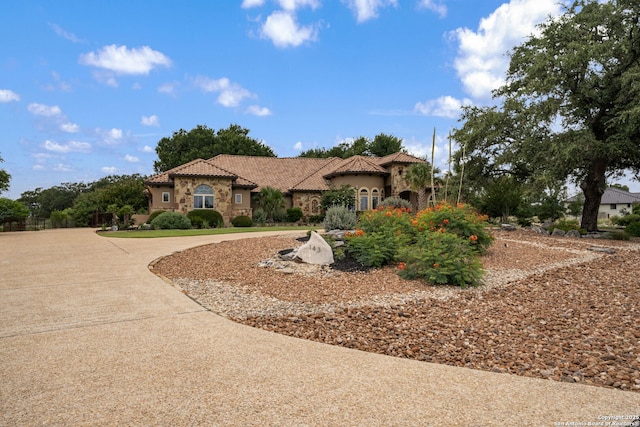 1437 Decanter, New Braunfels, TX 78132 - mediterranean / spanish home featuring curved driveway, a tiled roof, stone siding, and stucco siding
