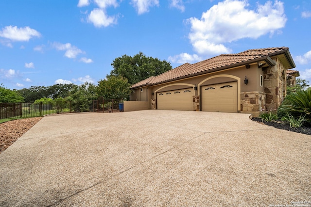 1437 Decanter, New Braunfels, TX 78132 - view of front of house with stone siding, driveway, an attached garage, a tiled roof, and stucco siding