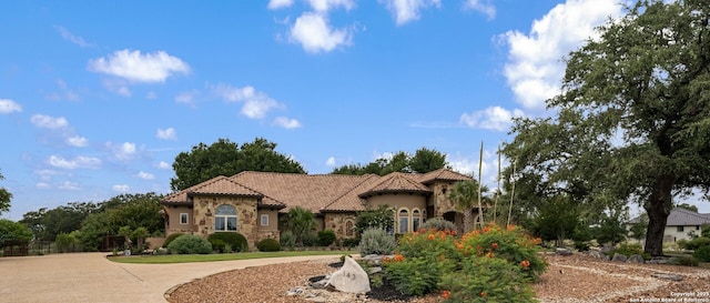 1437 Decanter, New Braunfels, TX 78132 - mediterranean / spanish home with a tile roof, stone siding, stucco siding, and curved driveway