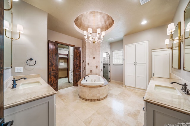 1437 Decanter, New Braunfels, TX 78132 - bathroom featuring a chandelier, two vanities, a garden tub, tiled shower, and a textured ceiling