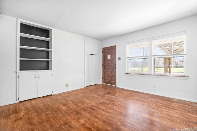 231 Craigmont, San Antonio, TX 78213 - unfurnished living room with wood finished floors and built in shelves