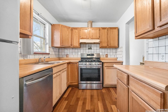 231 Craigmont, San Antonio, TX 78213 - kitchen featuring appliances with stainless steel finishes, wood finished floors, decorative backsplash, under cabinet range hood, and butcher block counters