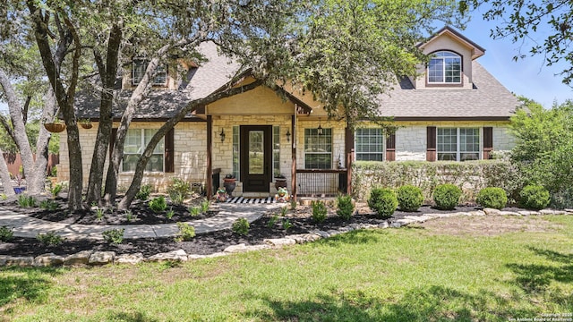 212 Wentworth, Spring Branch, TX 78070 - view of front of home with stone siding, a front yard, roof with shingles, and covered porch