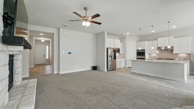 1606 Folk Victorian, New Braunfels, TX 78132 - unfurnished living room featuring ceiling fan, a stone fireplace, light carpet, and recessed lighting