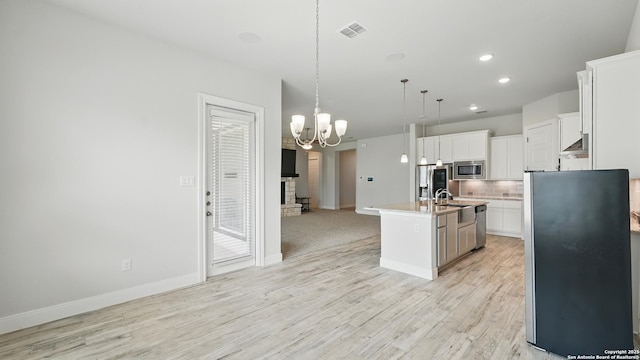 1606 Folk Victorian, New Braunfels, TX 78132 - kitchen with appliances with stainless steel finishes, a chandelier, tasteful backsplash, light wood-style flooring, and decorative light fixtures
