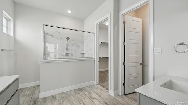 1606 Folk Victorian, New Braunfels, TX 78132 - bathroom featuring vanity, a marble finish shower, wood finished floors, a spacious closet, and recessed lighting
